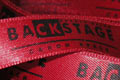 Брендированная лента с шелкотрафаретной печатью салона красоты Backstage, цвет ленты - красный, цвет краски - черный, ширина ленты - 15 мм, город Киев